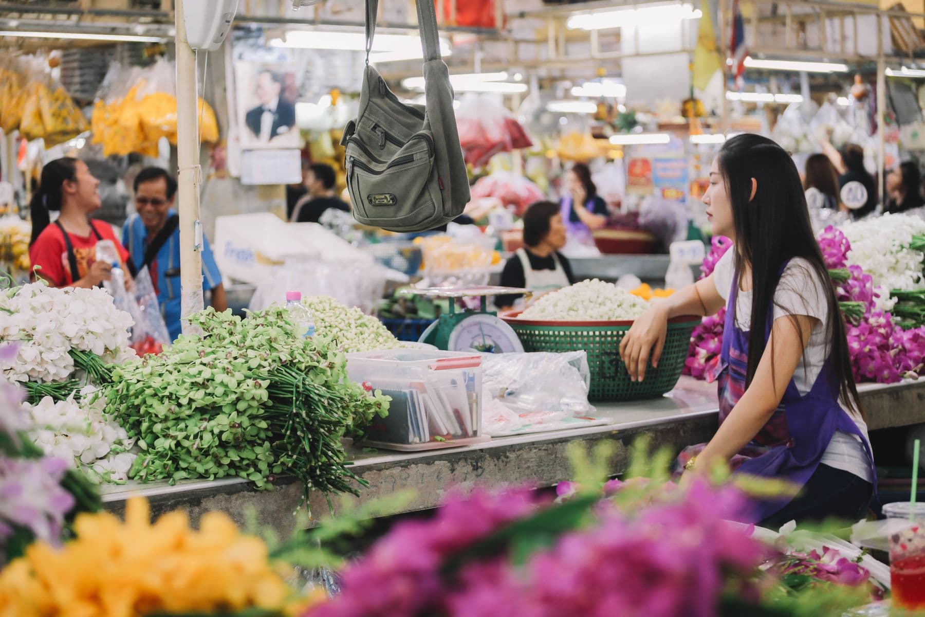 Two traders greeting each other across a busy market stall